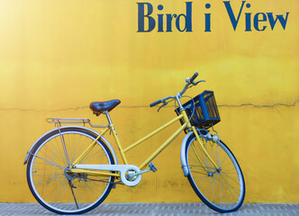 Bicycle travel idea and yellow wall