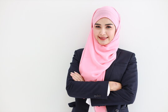 Pretty young asian woman wearing blue muslim suit smiling confident in studio. Isolated white background portrait with beautiful face girl with pink hijab. Advertisement portrait concept.