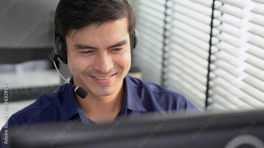 Aufkleber young competent asian male call center agent working at his computer while simultaneously speaking w