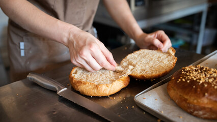 The baker cuts the finished brioche before laying the cream. Front view.