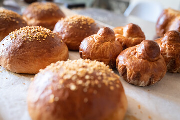 Ready-made brioches cool down on the table after baking. Front view.