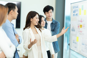 Business people showing team work while working in board room in office interior. People helping one of their colleague to finish new business plan. Business concept. Team work.