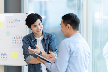 Business people showing team work while working in board room in office interior. People helping one of their colleague to finish new business plan. Business concept. Team work.