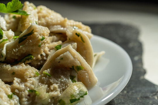 dish of buseca tripe with garlic and parsley on a black background mondongo 