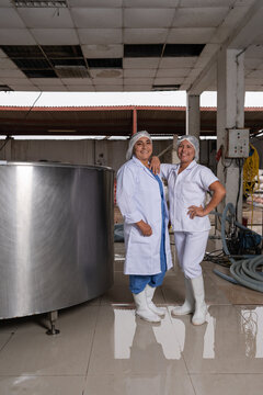 Portrait of a two workers in a dairy processing factory