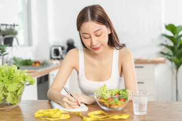 Diet, Dieting asian young woman working, write diet plan right nutrition, vegetables salad is food...