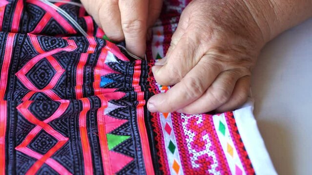 Handheld close up hand sewing make Hmong skirt, Making Hmong skirt