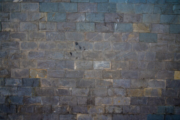 Grey stone wall with different sized stones, modern siding close up. Texture of a stone wall. Old...