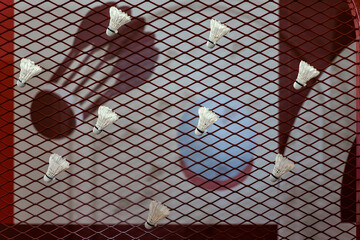 Shuttlecocks were stuck to the badminton steel grill net with a big red drawing of shuttlecock on...