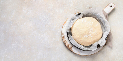 Raw dough pastry in a bowl on neutral background.