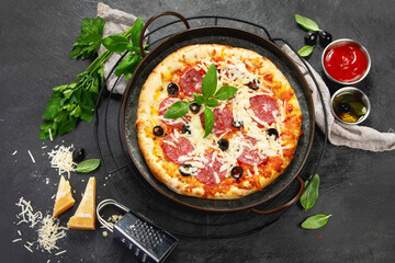 Freshly baked pepperoni pizza on dark background.