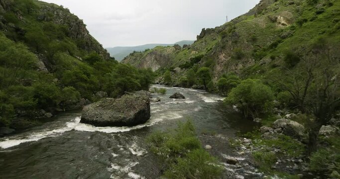 Rocky River Flowing In The Great Caucasus Mountains At The Base Of Tmogvi Castle Mount, Samtskhe-Javakheti Region, Georgia. Aerial Drone Shot