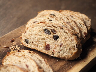 slice of whole wheat multigrain bread with dried fruit on wooden board