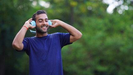 man in a relaxed mood listening to music in the park