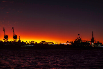 Cape Town Port sharply silhouetted against the bold orange and pink colors of a sunset sky