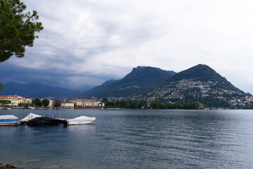 Scenic view of bay of Lake Lugano, Canton Ticino, on a cloudy summer day. Photo taken July 4th, 2022, Lugano, Switzerland.