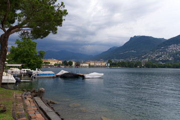 Fototapeta premium Scenic view of bay of Lake Lugano, Canton Ticino, on a cloudy summer day. Photo taken July 4th, 2022, Lugano, Switzerland.