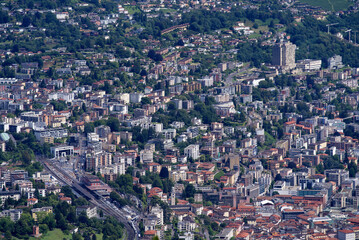 Fototapeta na wymiar Aerial view of City of Lugano seen from local mountain San Salvatore on a cloudy summer day. Photo taken July 4th, 2022, Lugano, Switzerland.