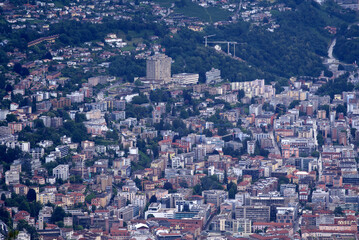 Aerial view of City of Lugano seen from local mountain San Salvatore on a cloudy summer day. Photo taken July 4th, 2022, Lugano, Switzerland.