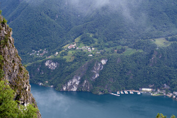 Fototapeta na wymiar Scenic landscape with mountain panorama and Lake Lugano seen from local mountain San Salvatore at City of Lugano on a cloudy summer day. Photo taken July 4th, 2022, Lugano, Switzerland.