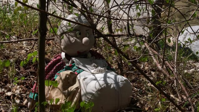 Abandoned old woman doll under the sun inside a forest