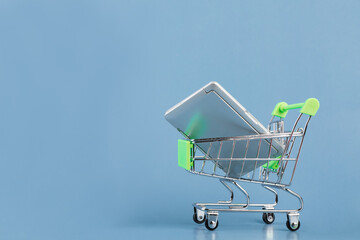 laptop in a supermarket trolley, black Friday, buying modern gadgets, sale, digital store