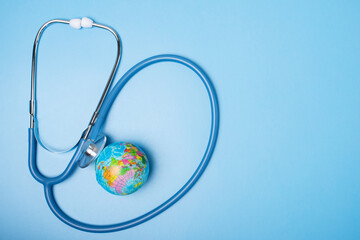 globe planet and stethoscope on blue background