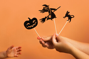 Halloween Theatre of shadows. Pumpkin jack o lantern. Paper dolls cat, witch. Child craft, party indoor activity