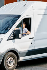 Young courier woman driving a van
