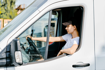 Naklejka premium Young woman driving a van