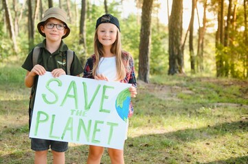 Children are holding a poster: Save the planet. Earth Day. Let's save the planet from pollution.