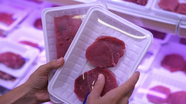 High quality meat cut into portions and put into portions in plastic packaging for cooking. A woman chooses fresh meat to prepare a delicious lunch. Eating meat on a keto diet.