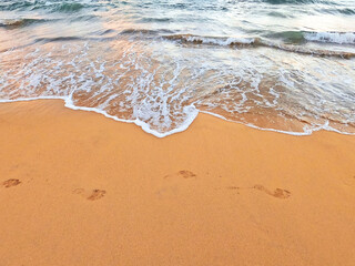 Sand beach background seaside with foamy sea wave