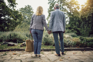 Obraz premium Elderly couple walking in park on sunny day