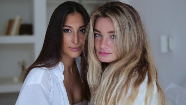 A portrait of two lesbians who are open to the whole world without hiding their orientation. The blonde and the brunette look into the frame. Relationships between women lovers.