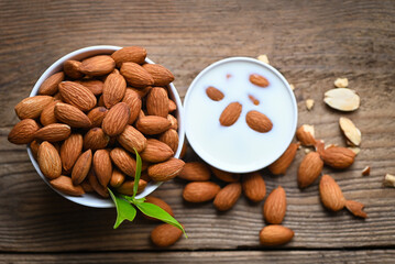 Almond milk and Almonds nuts on on wooden background, Delicious sweet almonds on the table, roasted almond nut for healthy food and snack - top view