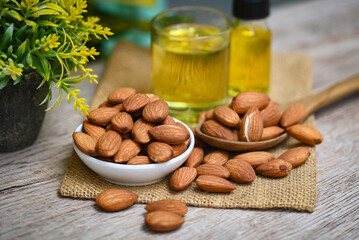 Almond oil and Almonds nuts on wooden, Delicious sweet almonds oil in glass, roasted almond nut for healthy food and snack organic vegetable oils for cooking or spa concept - 526663479