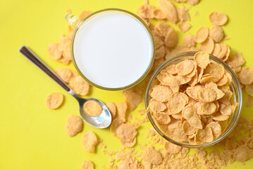 cornflakes bowl breakfast food and snack for healthy food concept, morning breakfast fresh whole grain cereal, cornflakes with milk on yellow background - top view