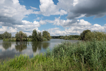 Polder landscape photo with water and a blue cloudy sky