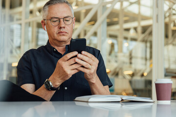 Male entrepreneur using mobile phone at desk in office