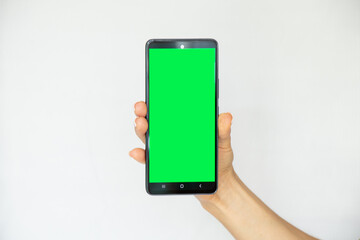A girl on a white background in her hand holds a mobile phone with a green screen, a template with a phone, a green screen