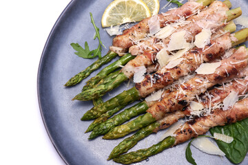 Healthy food - Asparagus wrapped with bacon and spices on a plate isolated on white background