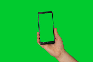 A man's hand on a green background holds a mobile phone with a green screen, a template with a...