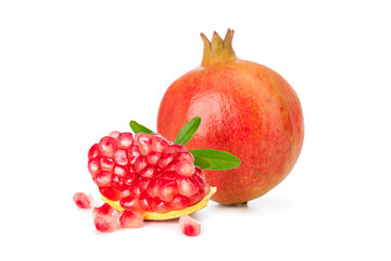 a whole pomegranate fruit with seeds and green leaves on white background.