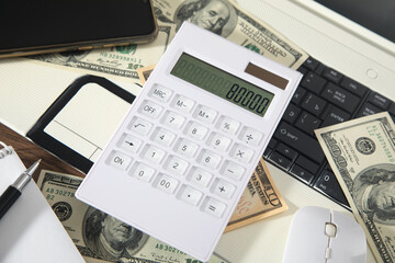 Computer mouse, calculator and money on computer keyboard.