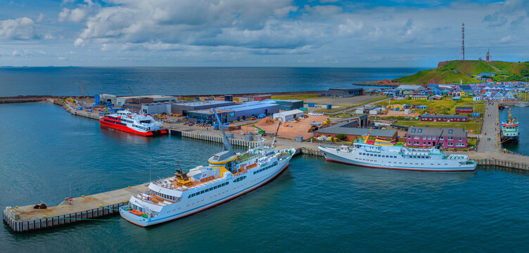View from the water to the south port of Helgoland with the Helgoland ferrys and the Helgoland houses. Aerial view at south harbor with ferrys and houses of German island Helgoland in the Northsea.  