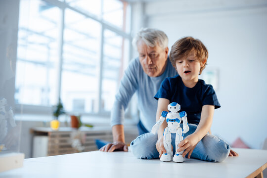 Boy with robot model by grandfather at home