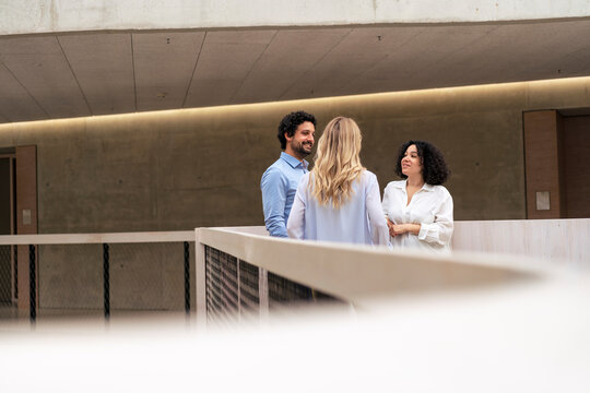 Multiracial Business Business Colleagues Discussing In Corridor