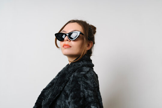 Confident woman wearing sunglasses in studio