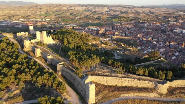 Picturesque aerial view of remains of ancient moorish Ayub Castle with fortification walls on top of green hill above Spanish city of Calatayud in province of Zaragoza on sunny spring day. High